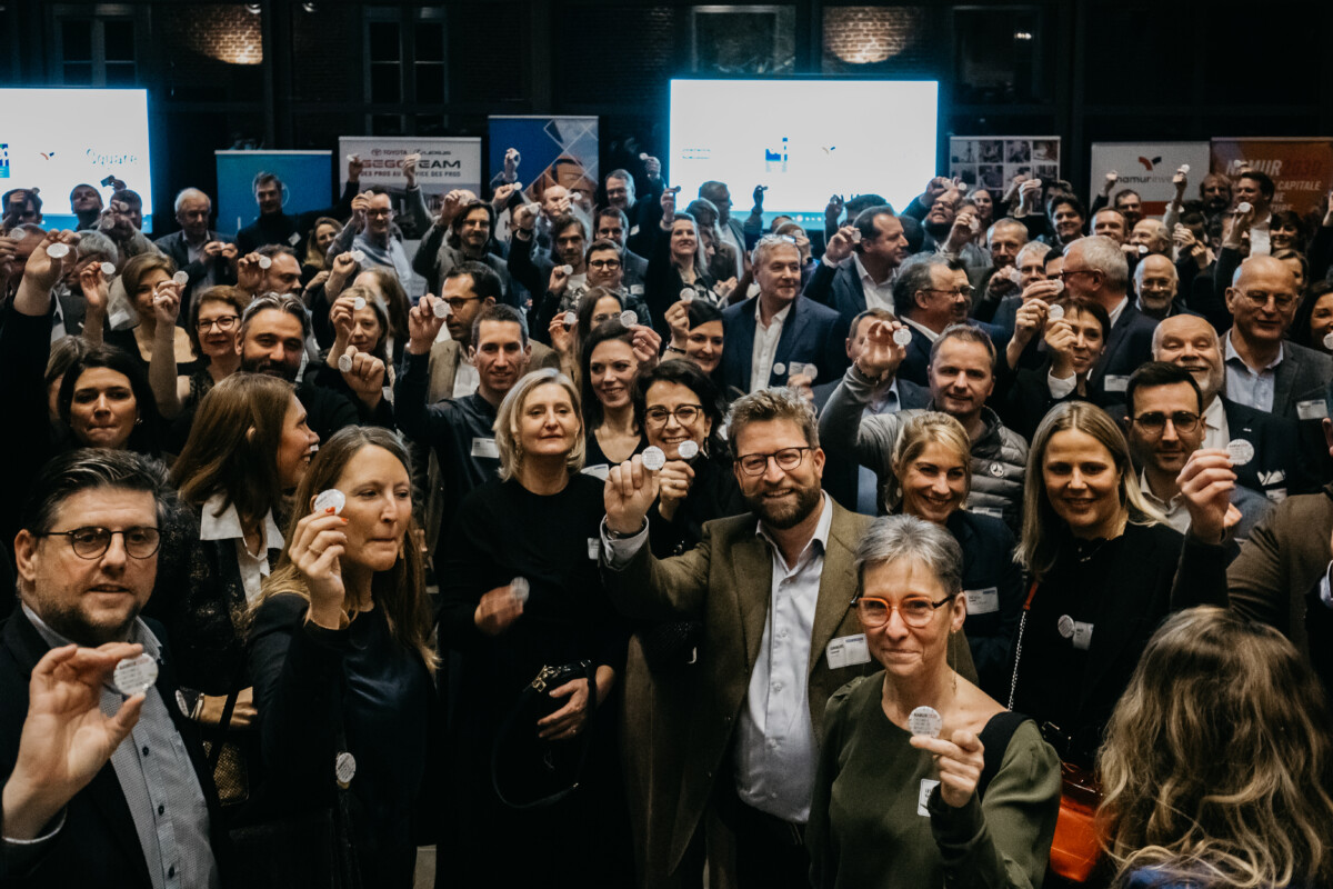 Des entrepreneurs et entrepreneuses avec le badge à l'effigie de la candidature entre les mains